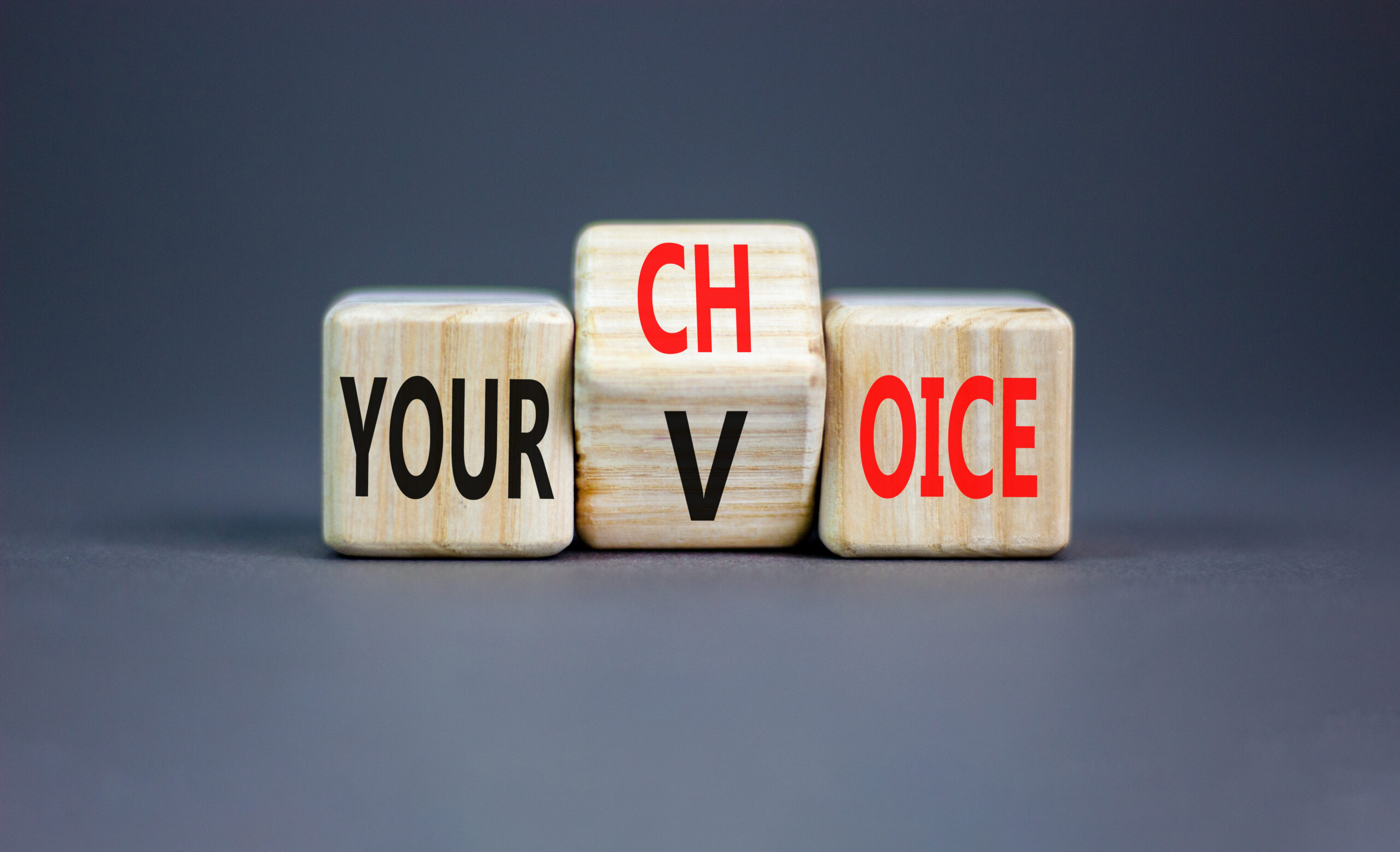 Your voice choice symbol. Wooden cubes with one cube changing "Voice" to "Choice"