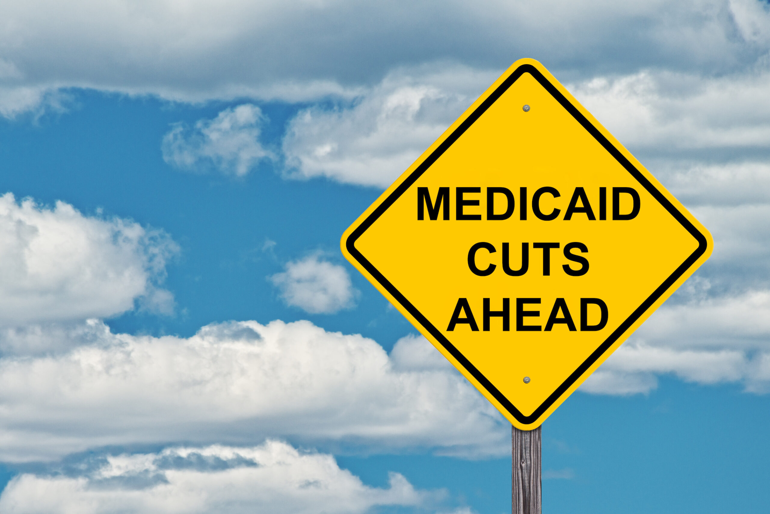"Medicaid Cuts Ahead" Caution Sign With Blue Sky Background