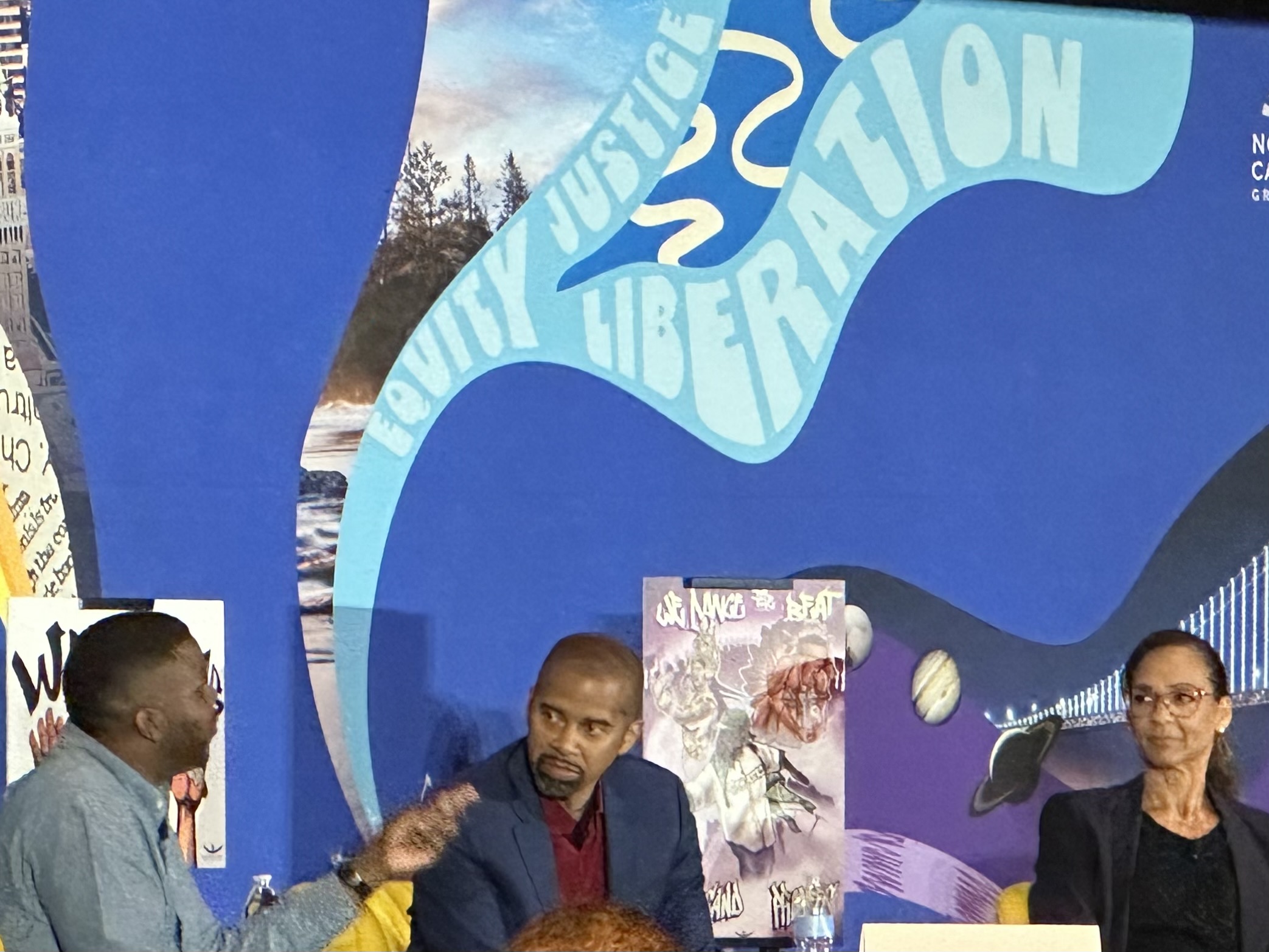 three panelists in discussion at a conference