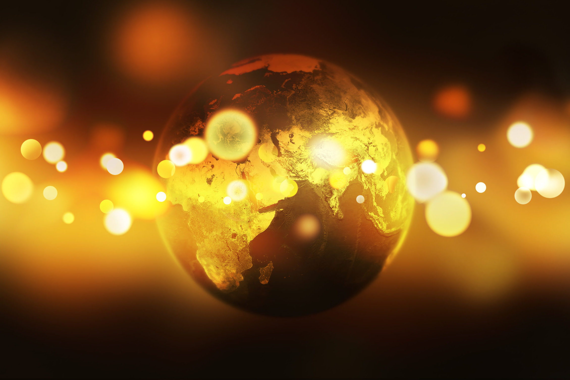 Earth globe over golden bokeh background.