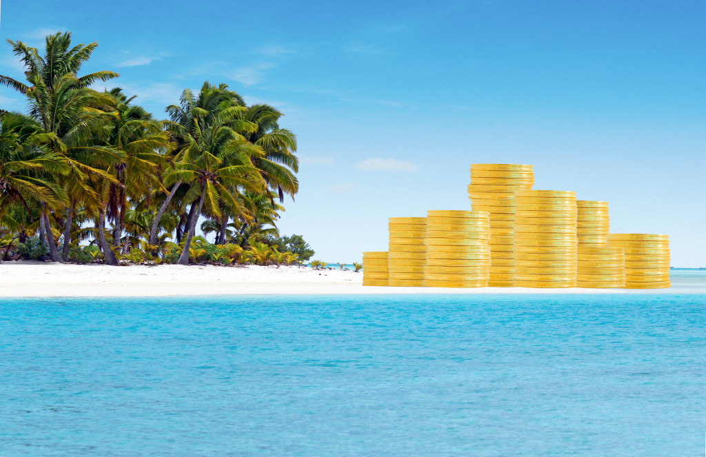 Offshore banking and tax havens concept with golden coins on sand island and palm trees. Copy space