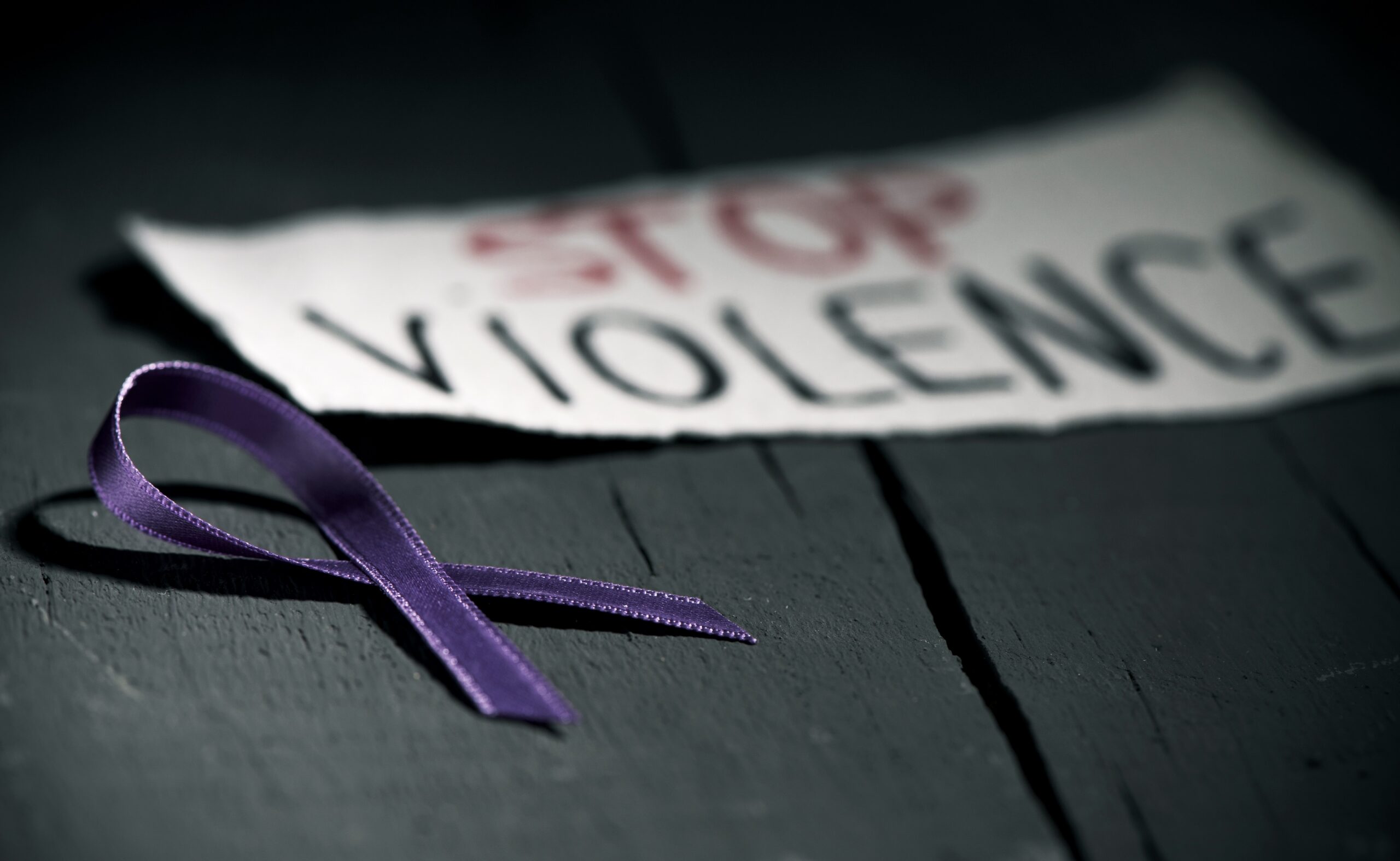 purple ribbon and "STOP VIOLENCE" sign