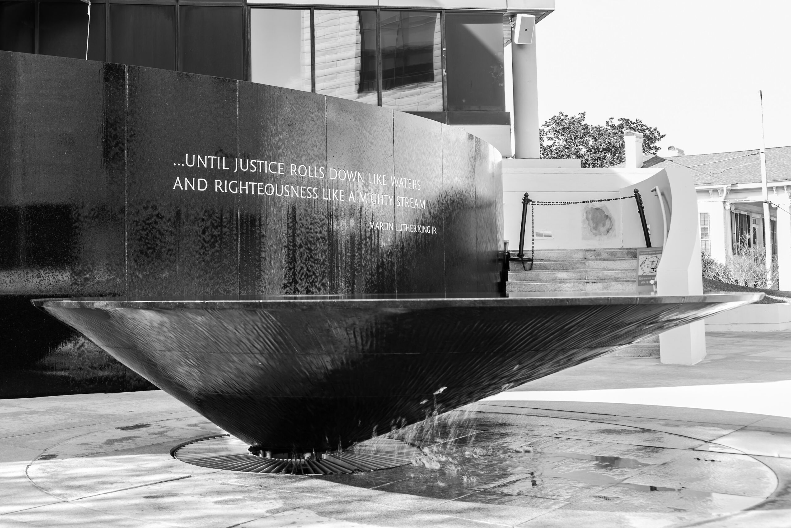 photo of sign with Martiin Luther King, Jr. quote: "... until justice rolls down like waters and righteousness like a mighty stream"