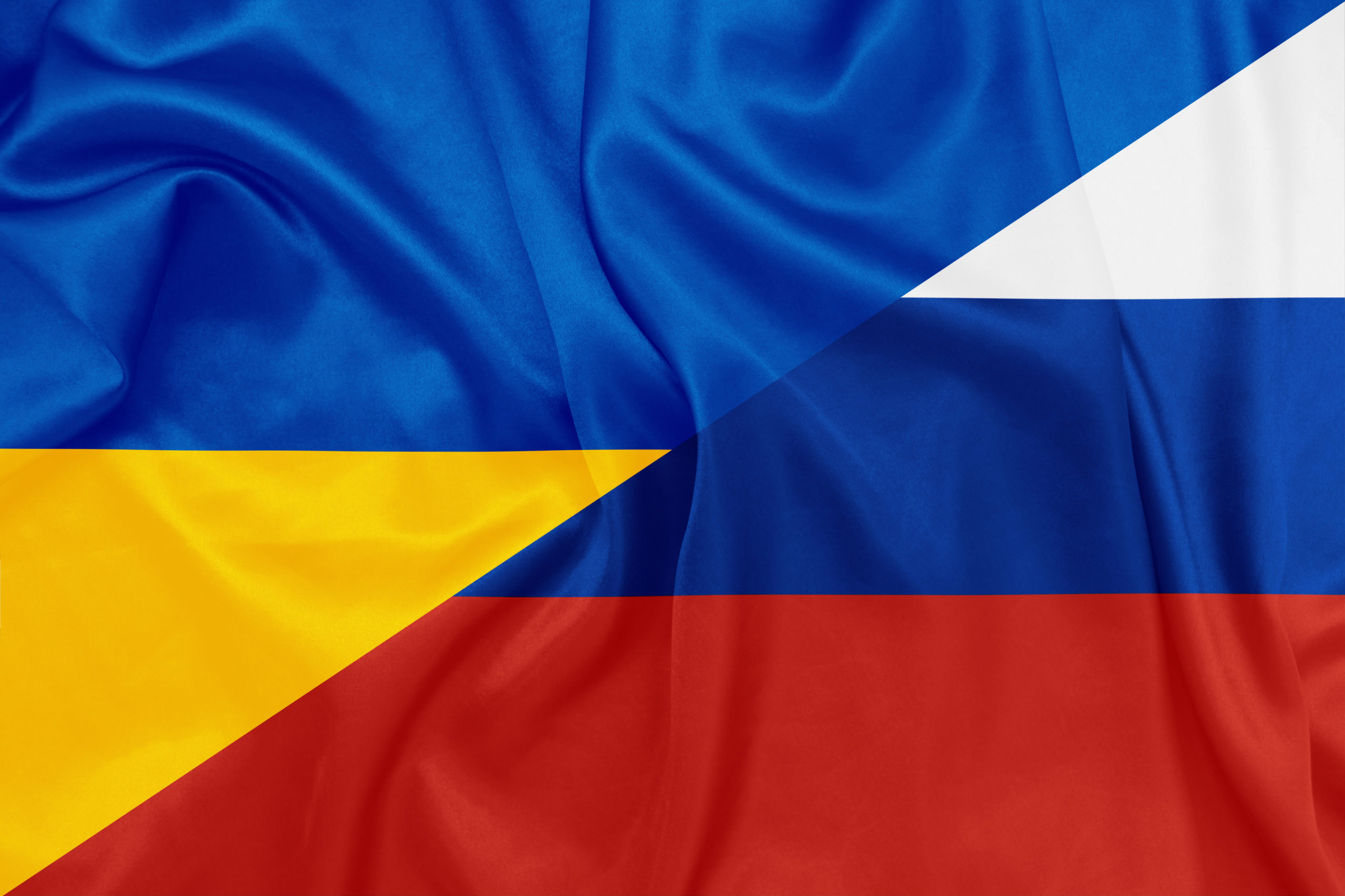 Russia and Ukraine national flags on silk texture