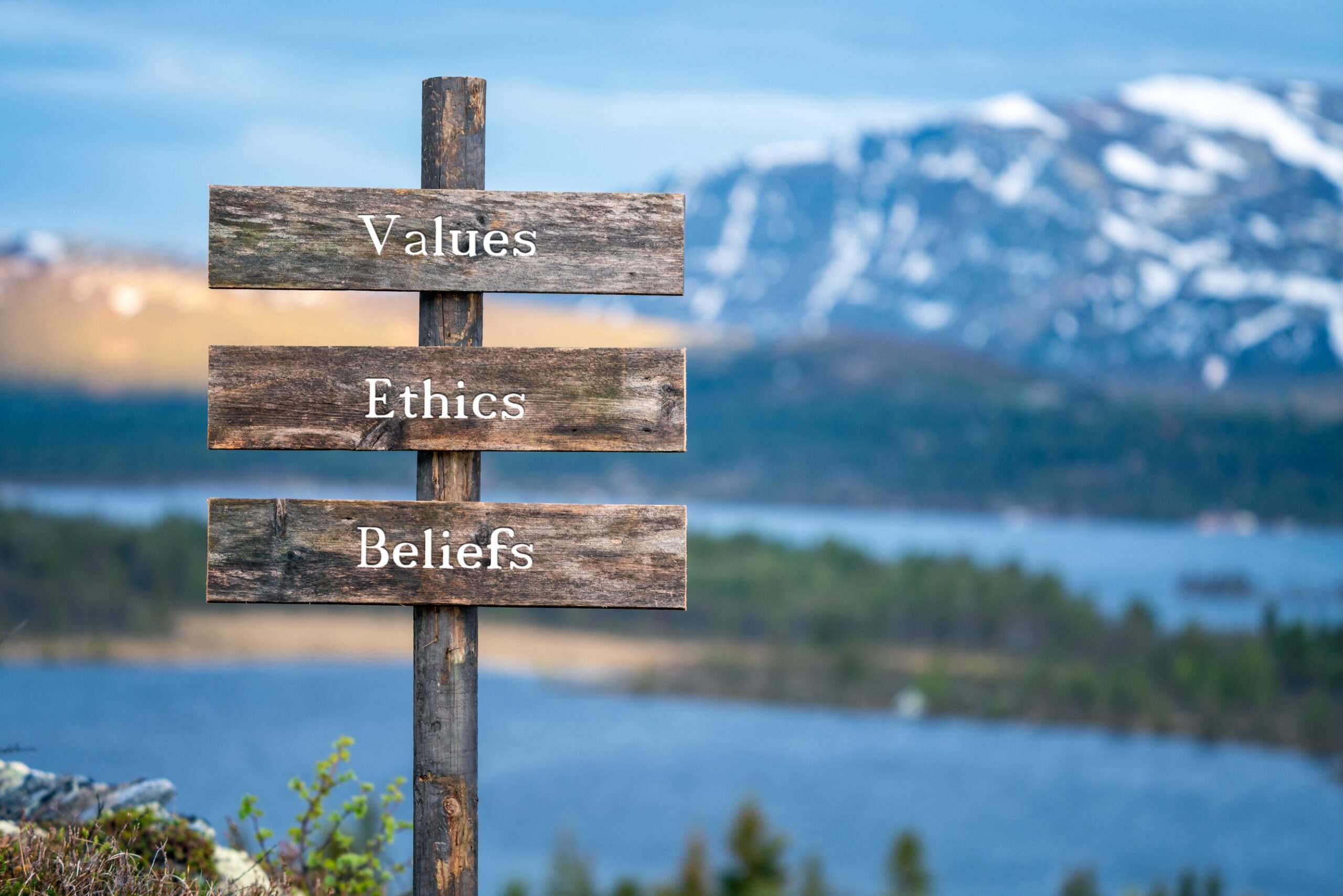 "values" "ethics" "beliefs" on wooden signpost outdoor with mountain background